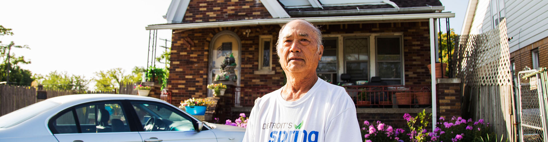 Naoying Yang stands in front of his house in Detroit